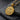 Angled perspective of the Saint Benedict medallion showing detailed engraving and premium metal finish on rugged slate