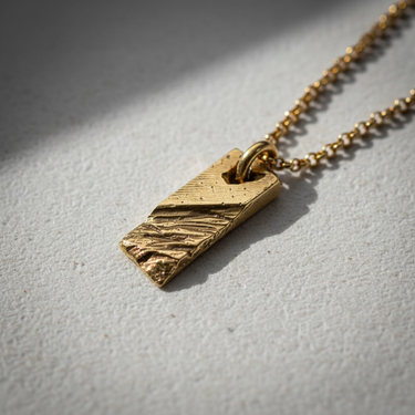 Side perspective of textured bar pendant highlighting handcrafted metalwork and sturdy bail loop design