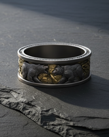 Angled view of wide band sterling silver bear ring with nordic design displayed on dark slate stone surface