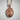 Saint James Pilgrim Pendant, rose gold plated silver, front view against white wall