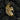 Close-up of the radiant gold Pegasus pendant resting on dark textured charcoal, highlighting the detailed craftsmanship