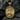 Close-up of luxurious gold plated Saint Michael pendant resting elegantly against a textured dark stone background