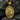 Close-up of gold Christian medallion depicting Saint Apostle Paul resting on a dark textured rock background