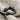 Close-up of the oxidized silver hugging hands ring resting on textured fabric highlighting intricate hand details