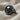 Round Skull Signet Ring, black rhodium plated, angled view on fabric