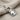 Bow Tie Cat Pendant, polished, angled view on linen