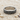 Close-up of the vintage scroll ring resting on fine sand and shells, highlighting the intricate 925 silver metalwork