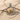 Close-up of the two-tone Taurus bull pendant resting on natural sand with wooden twigs highlighting details