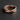 A sterling silver Mobius ring lying flat on a dark slate background, highlighting the elegant infinity curve and form.