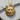 Handcrafted gold vermeil cat face pendant resting on textured natural wood showcasing intricate 3D details
