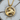 Close-up of 925 sterling silver Taurus zodiac pendant with gold vermeil resting on a rustic wooden slice