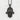 Lotus Eye Hamsa Hand Pendant in black rhodium, front view against textured wall