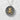 Close-up of the oxidized silver kanji beauty pendant with gold vermeil detailing resting on a textured white surface