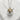 Handcrafted silver and gold takoyaki pendant necklace resting against a textured white stone highlighting fine details.
