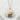 Close-up of two-tone onigiri pendant resting on white stone highlighting gold lettering and silver rice