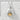 Smiling onigiri pendant crafted in 925 sterling silver and gold vermeil resting gently on a textured white stone.