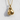 Close-up of handcrafted 14K gold vermeil boxing gloves pendant casting shadow on textured white wall background
