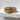 Close-up view of vintage scrollwork ring resting on white textured surface highlighting engraved details