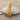 Little Prince Sword Pendant, gold vermeil, angled front view on pebble