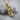 Cracked Skull Bullet Pendant, gold vermeil, angled view on textured stone