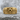 Studded Skull Ring, gold vermeil, front view on stone surface