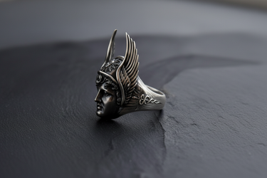 Side profile of silver Hermes ring showing the winged petasos helmet and caduceus staff carved into the oxidized silver band