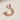 Twisted Crescent Star Pendant, rose gold, front view with cast shadow on textured stone