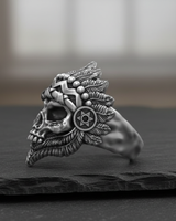 Side profile of sterling silver skull ring highlighting feather texture and geometric band patterns