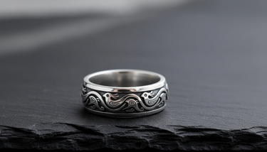 Close up detail of stylized bird motif and scrollwork on handcrafted oxidized silver ring for men and women