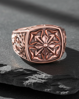 Close up of medieval cross ring design showing high polish details and textured background craftsmanship