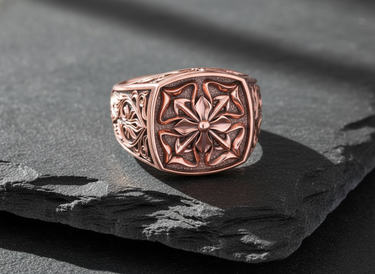 Close up of medieval cross ring design showing high polish details and textured background craftsmanship