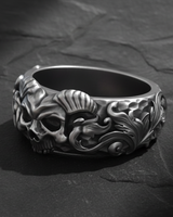 Side profile of silver skull ring showing detailed hammered texture and oxidized floral scrollwork design