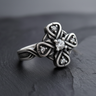 Angled view of 925 sterling silver Celtic cross ring with central clear stone and intricate knot details on dark stone