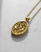 Gold vermeil over 925 sterling silver Artemis pendant featuring goddess of the hunt and stag relief on concrete background