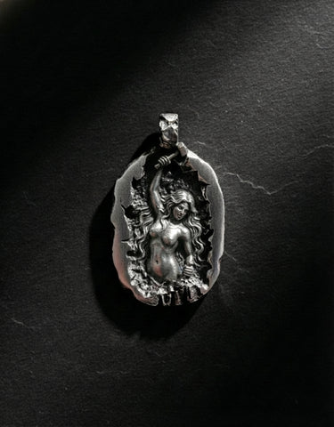 Front view of handcrafted silver sculpting woman pendant highlighting hammer and chisel details on black background