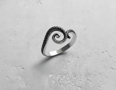 Angled view of sterling silver tentacle ring highlighting the polished band and darkened details of the sea creature design