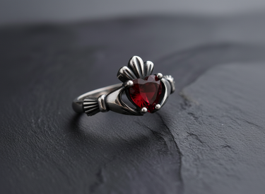 Close-up of red heart shaped gemstone and silver crown design on a vintage style Celtic Claddagh ring