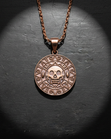 Close-up of handcrafted skull medallion showing intricate relief and antique finish