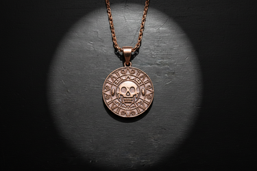 Close-up of handcrafted skull medallion showing intricate relief and antique finish