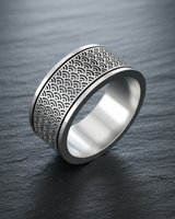 Angled view of handcrafted silver ring showing oxidized ocean wave design and polished inner band