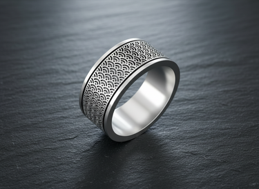 Angled view of handcrafted silver ring showing oxidized ocean wave design and polished inner band