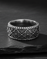 925 sterling silver antique band ring with intricate quatrefoil pattern on dark stone background