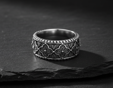 925 sterling silver antique band ring with intricate quatrefoil pattern on dark stone background