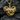 Close-up of the intricately detailed gold elephant heart pendant resting elegantly on a dark textured rock