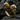 Eye-catching gold twin skull ring resting on dark textured stone, highlighting the premium craftsmanship and design
