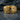 Detailed side view of the vintage floral ring in gold vermeil set against a dark textured stone background
