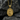 Close-up of gold vermeil Catholic Christian pendant with Saint Barbara holding a cross and tower on dark rock