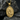 Close-up of gold Saint Anthony pendant resting on dark stone showing detailed Catholic medallion design.