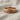 Close-up of premium celtic braided ring resting on textured fabric highlighting the polished rose gold finish