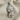 Ornamental Skull Pendant, polished, front view on fabric